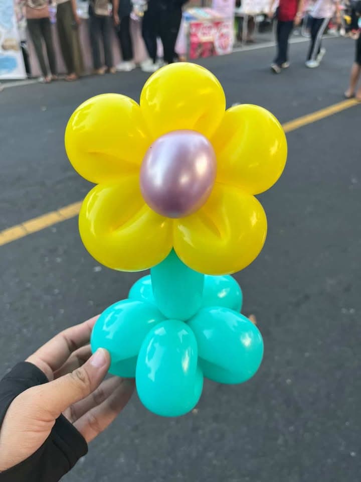 Bunga balon kuning dengan pusat ungu dan tangkai biru kehijauan