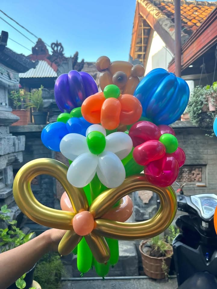 Buket bunga balon aneka warna dengan pita emas di luar ruang
