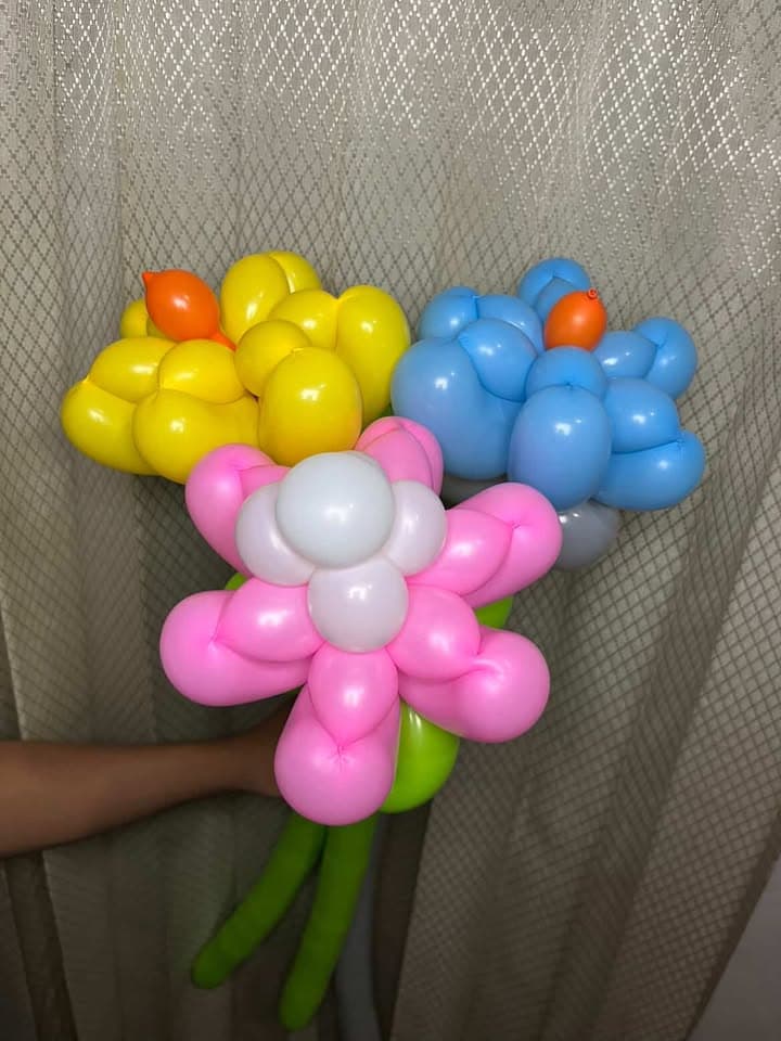Rangkaian bunga balon kuning, merah muda, dan biru