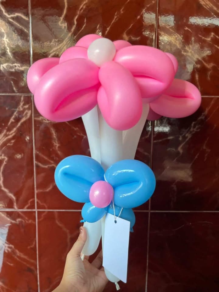 Bunga balon merah muda dengan pita biru dan tangkai putih